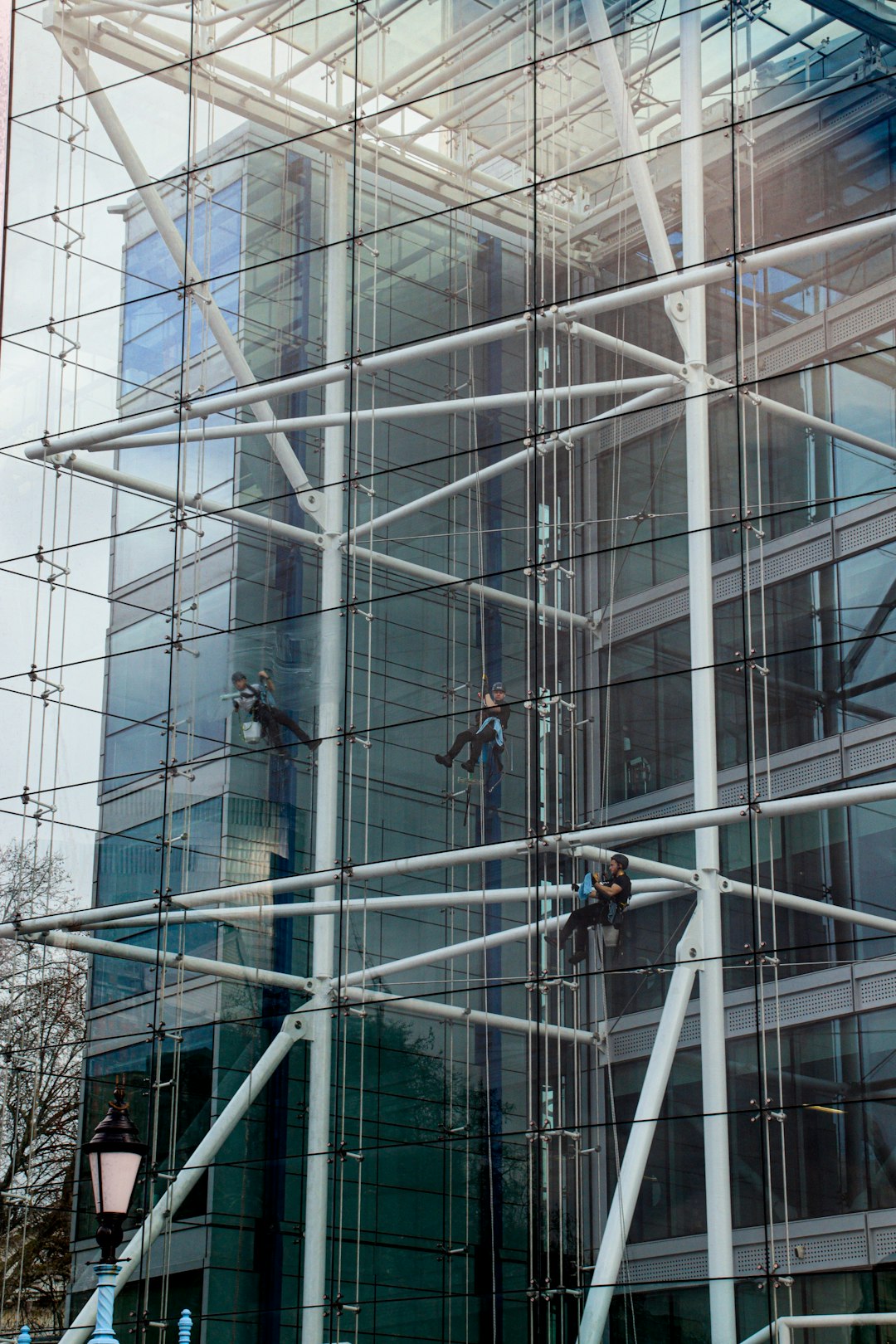 Window cleaners working from ropes on the inside of a Tower Bridge House London
